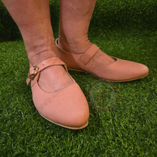leather buckled shoes being worn on grass